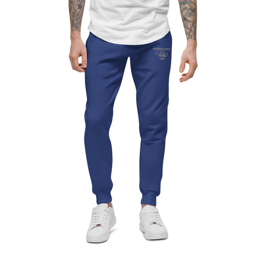 Blue unisex joggers with EST.1990 logo on the left leg, worn by model